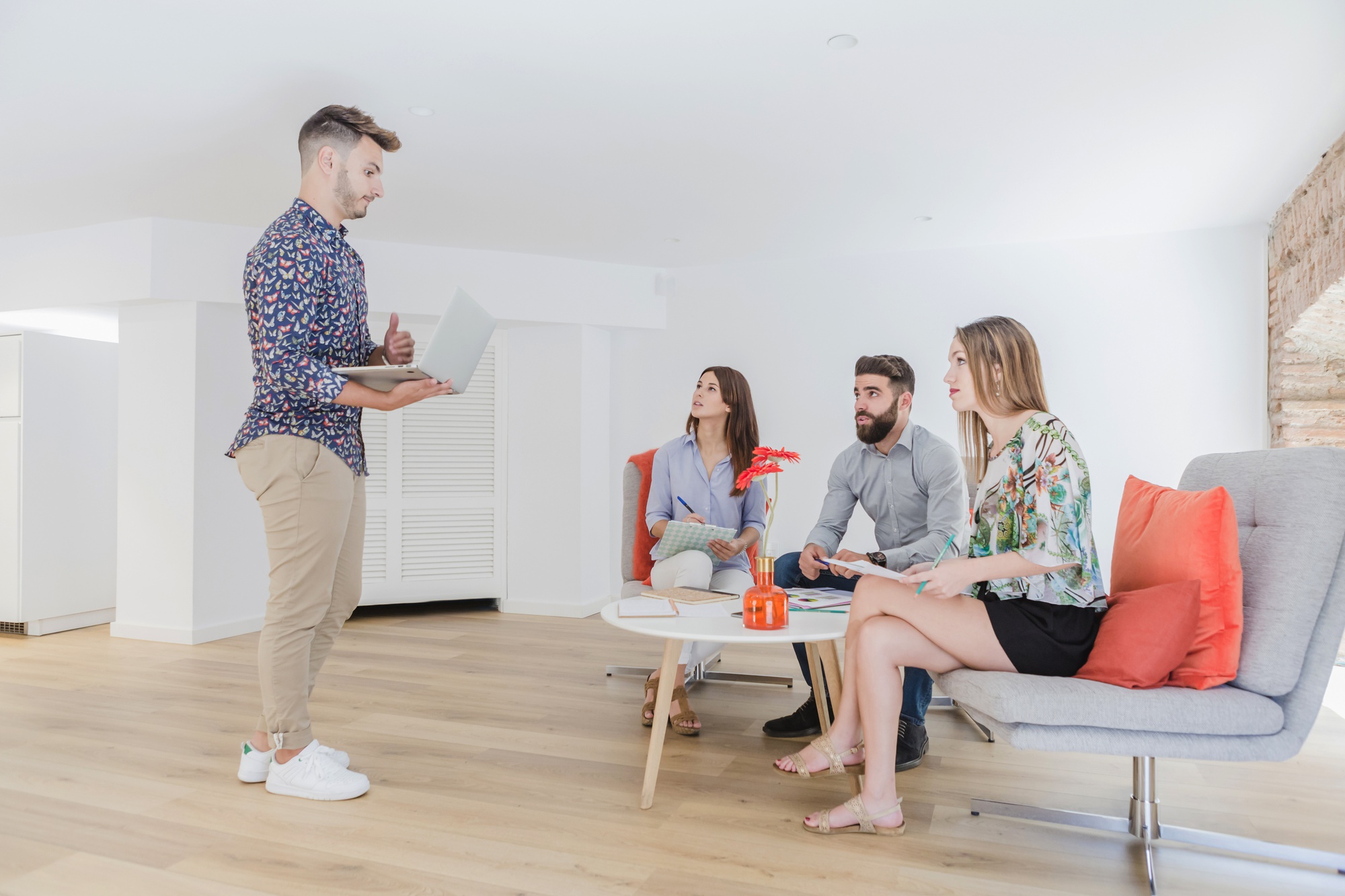 Agent imobiliar discutând cu proprietar într-un apartament luminos